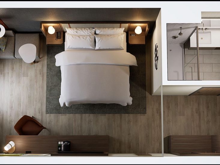 Aerial view of a modern hotel room at Holiday Inn Nashville Airport, featuring a neatly made king bed, stylish furniture, and a sleek bathroom