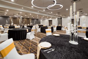 Round tables with white linens set for a party in the ballroom at Holiday Inn Nashville Airport near BNA