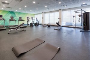 Modern hotel fitness center at Holiday Inn Nashville Airport with cardio machines, strength equipment, and yoga mats in a bright, spacious room.