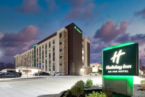 Exterior view of Holiday Inn Nashville Airport at night, illuminated with warm lights and clear hotel signage, showcasing the welcoming entrance and modern architecture.