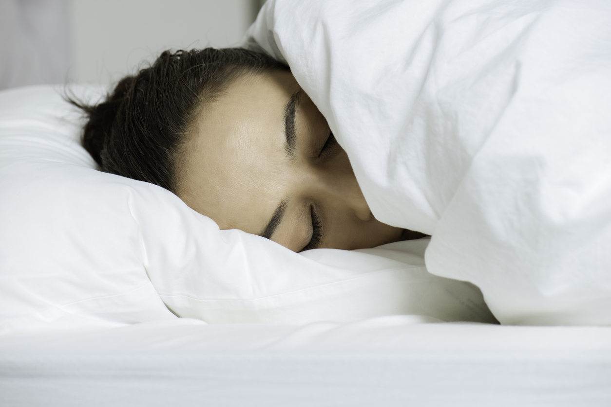 Woman sleeping in a cozy bed at Holiday Inn Nashville Airport near Nashville International Airport (BNA).