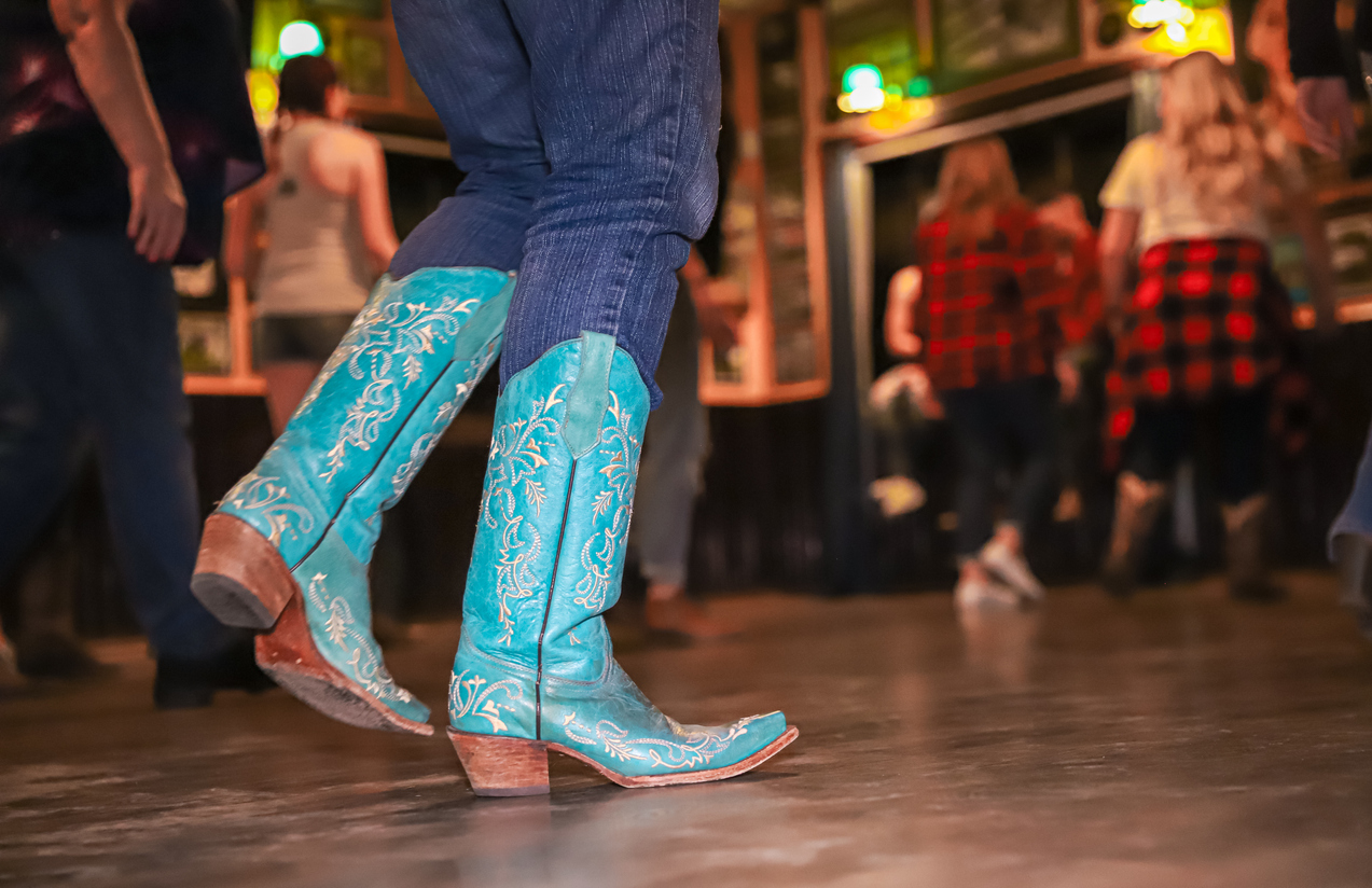 Female line dancing in cowgirl boots at a local Nashville bar near Music Valley and Nashville Airport